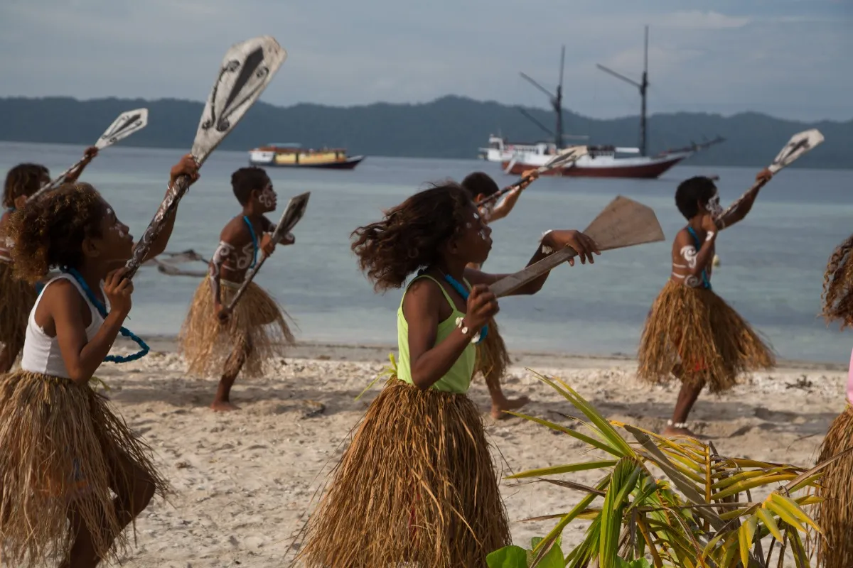 Raja Ampat boottocht jubileumreis zee varen eiland locals dansen